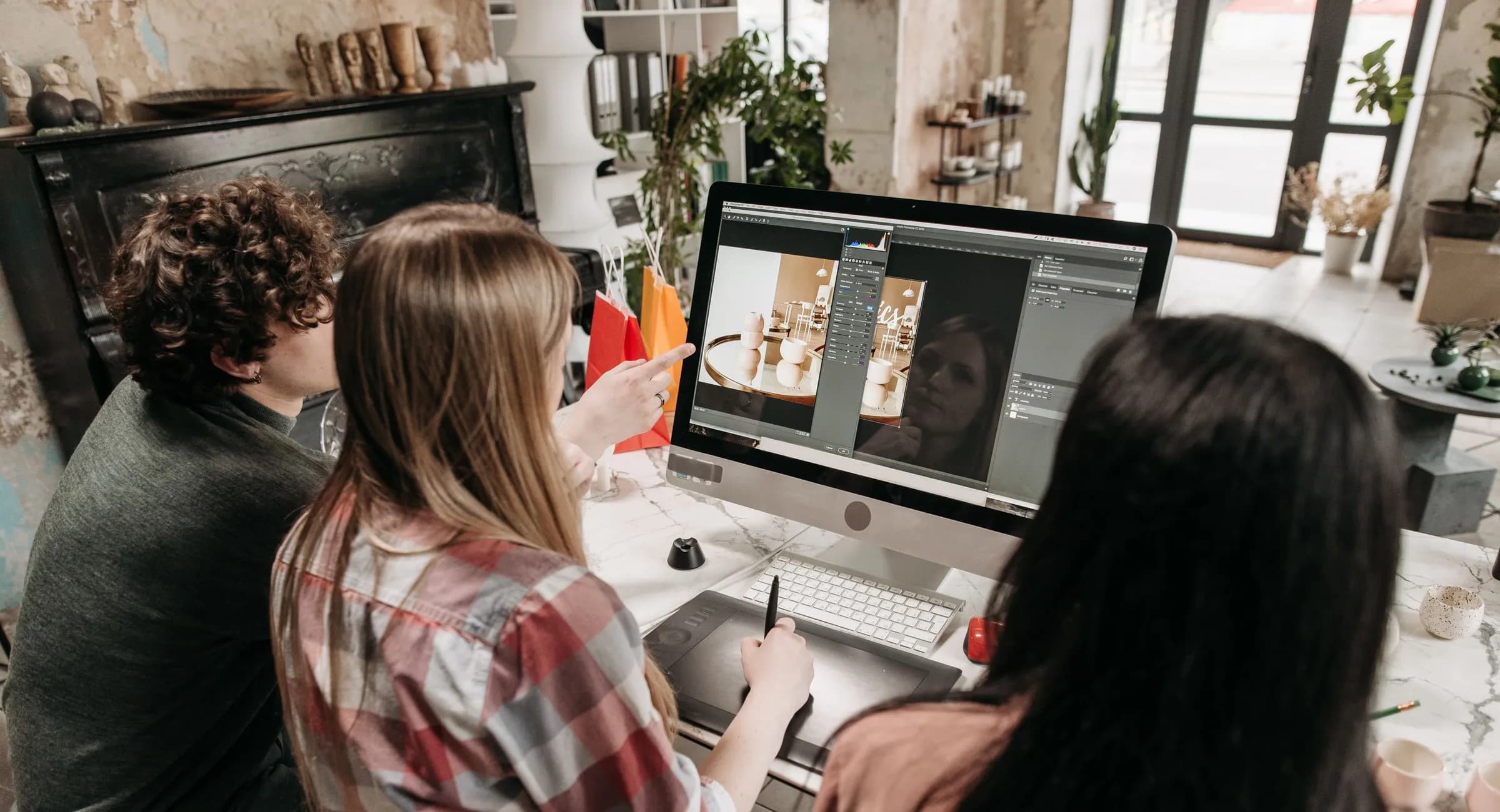 A small creative team reviewing a design together at a studio desk